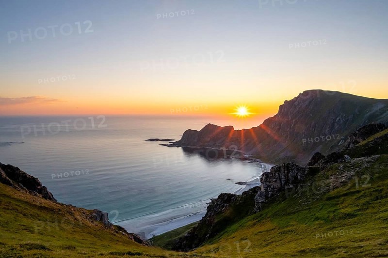 View of coastal landscape at sunset, cliffs and summit of Måtind or Måtinden, Høyvika beach and sea, Andøya island, Vesterålen, Nordland Norway