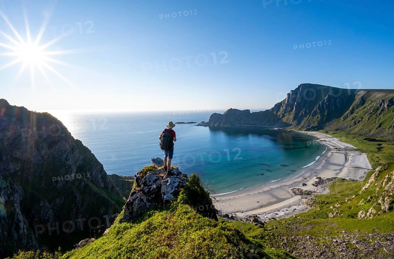 Mountaineer with view of coastal landscape, steep coast with summit Måtind or Måtinden, Høyvika beach and sea, hike to the summit of Måtind, Sun Star, Andøya Island, Vesterålen, Nordland, Norway, Europe