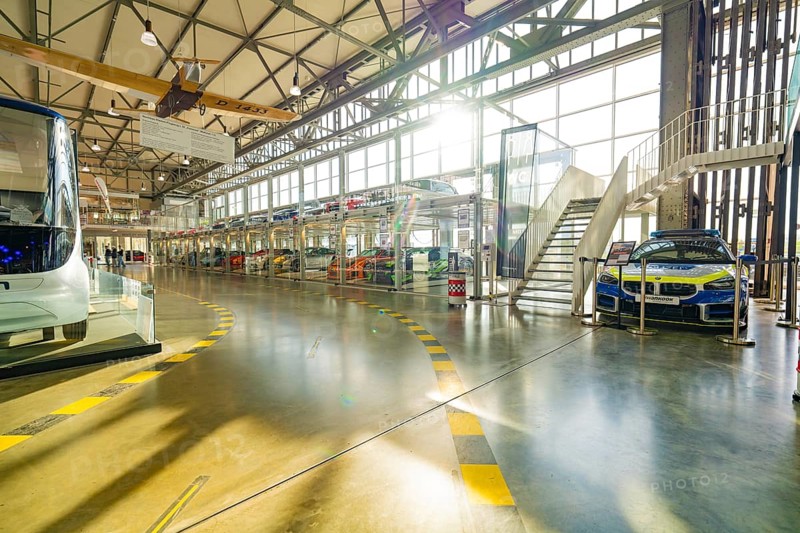 Hall with glass garage full of cars, direct sunlight and modern architecture, Motorworld Böblingen, Germany, Europe