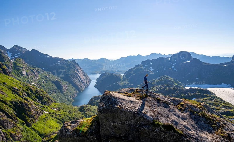 Mountaineer, young man hiking in front of mountain landscape, fjord Trollfjord and mountains, hike to Trollfjord Hytta, at Trollfjord and Raftsund, Lofoten, Nordland, Norway, Europe