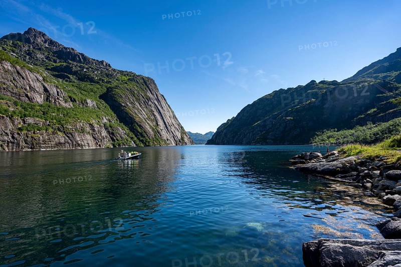 Motorboat with tourists in the fjord Trollfjord, mountains reflected in the water, fjord landscape and mountains, Lofoten, Nordland, Norway, Europe