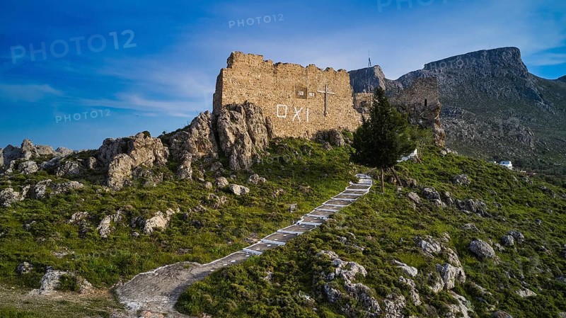 Drone shot, stone ruin on hill with paved path in mountainous landscape under blue sky, Archangelos, castle, place, castle of Archangelos, Rhodes, Dodecanese, Greek Islands, Greece, Europe
