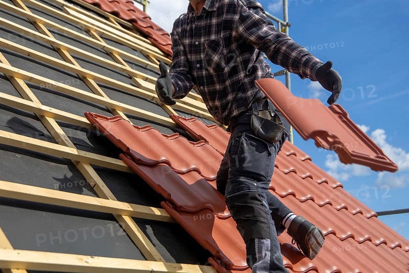 Roofer covering a tiled roof