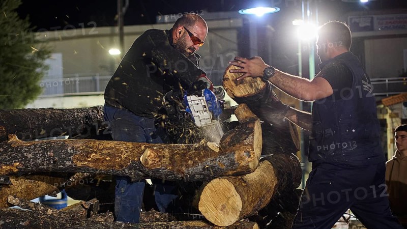 ©Udo Rein, A man cuts wood with a chainsaw while the other helps, Easter fire Psinthos, Holy Saturday, Easter, Psinthos, Rhodes, Dodecanese, Greek Islands, Greece, Europe