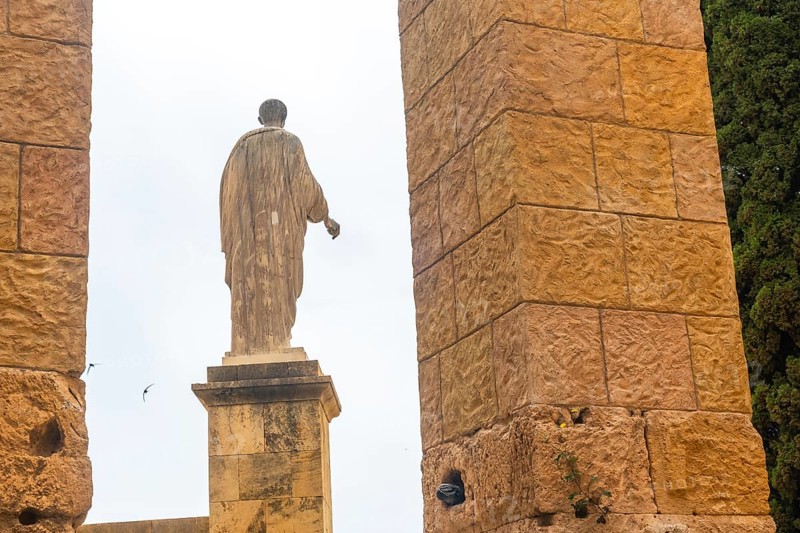 Ancient roman statue standing tall amidst the ruins of tarragona, showcasing the city's rich historical heritage
