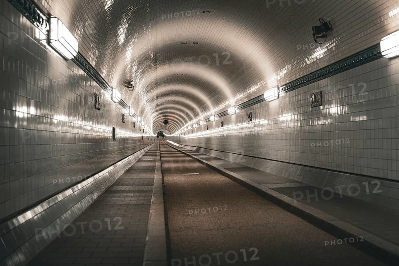 Symmetrically illuminated tiled tunnel with curved lines and depth, old Elbe tunnel, Hamburg, Germany, Europe
