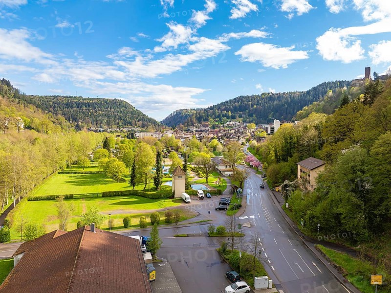 View of town with neighbouring forest and hills under blue sky, Bad Liebenzell, district Calw, Black Forest, Germany, Europe