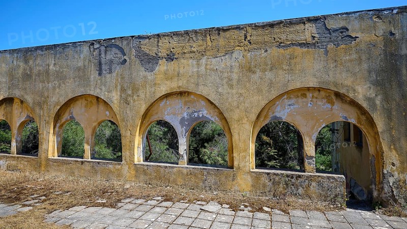 Dilapidated yellow arches in the exterior of a ruined building with visible structural damage, Lost Place, Former Santorium, Tuberculosis Centre 1947-1970, Former Italian colonial settlement, Eleousa, Campochiaro, Rhodes, Dodecanese, Greek Islands, Greece, Europe