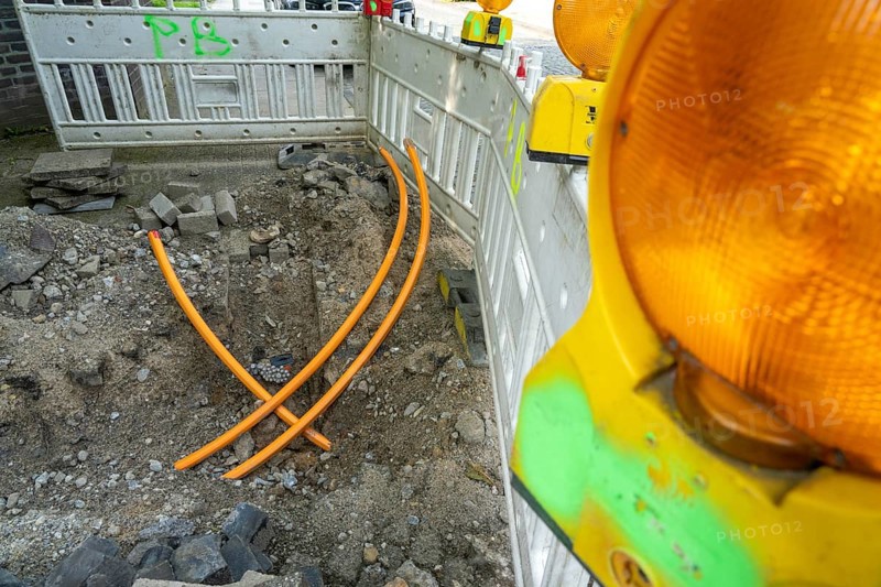 Laying of fibre optic cables, empty conduits are laid under a pavement, in which the actual fibre optic cable is later blown in and connected to the respective house connection or distributor. Essen, North Rhine-Westphalia, Germany, Europe
