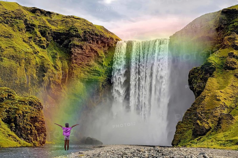 Child in front of Skogar waterfall rainbow Iceland