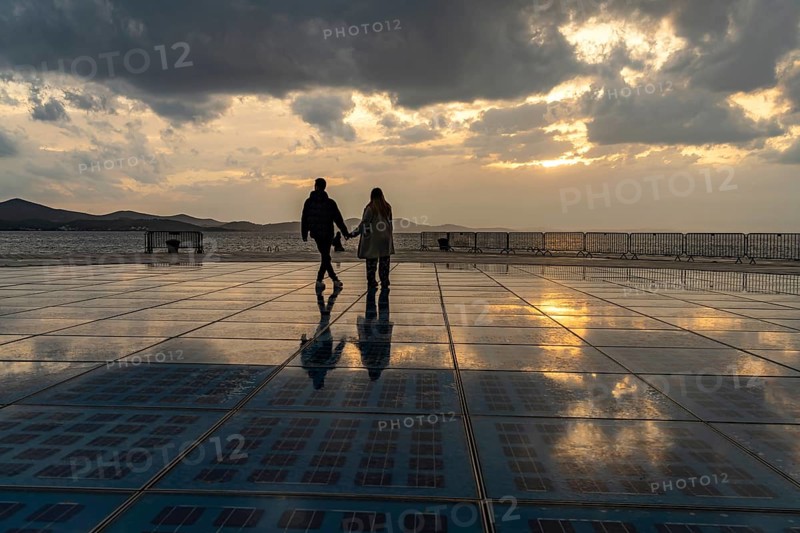 Couple on the solar installation Greeting to the sun at sunset, Zadar, Croatia, Europe