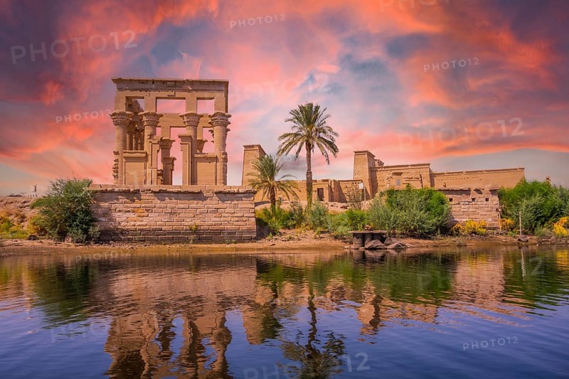 Incredible orange sunrise at the temple of Philae, a Greco-Roman construction seen from the Nile river, a temple dedicated to Isis, goddess of love. Aswan. Egyptian