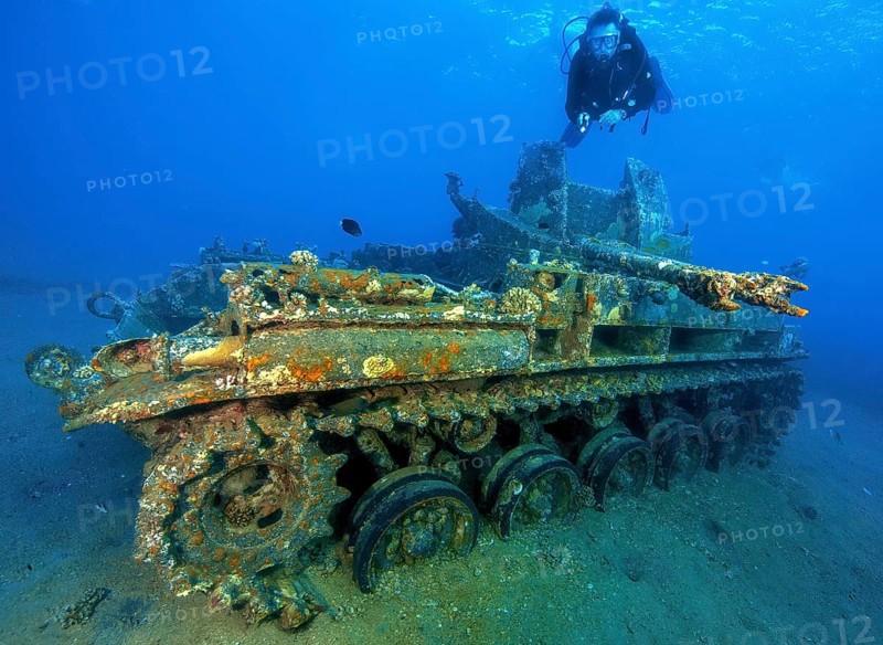 Underwater photo of diver swimming above looking at as an attraction for underwater sportsmen sunken US American tank M42 Duster with anti-aircraft gun at dive site Seven Sisters, Red Sea, Gulf of Aqaba, Aqaba, Aqaba, Jordan, Asia