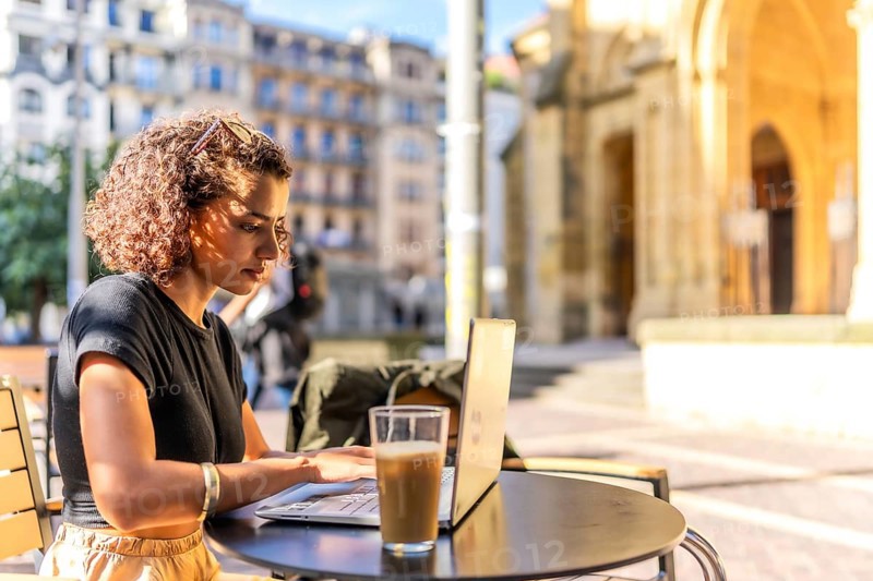 Horizontal photo with copy space of a Young arab entrepreneur working with laptop in sidewalk cafeteria