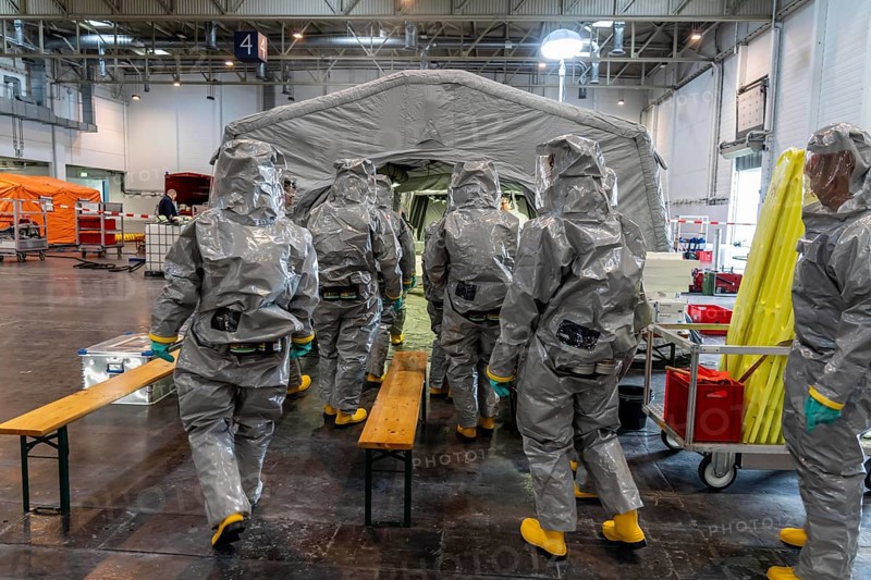 Decontamination of injured persons after an assumed accident involving hazardous substances, fire brigade and aid organisations practise setting up and operating a decontamination station, injured persons are sighted and then washed in a special shower tent to remove possible hazardous substances and chemicals in order to avoid further injuries, the emergency services wear special, ventilated protective suits, large-scale exercise by the Essen fire brigade