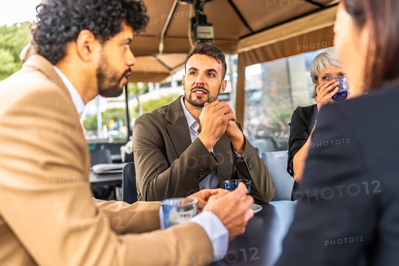 Business coworkers talking while drinking coffee during work break at cafeteria