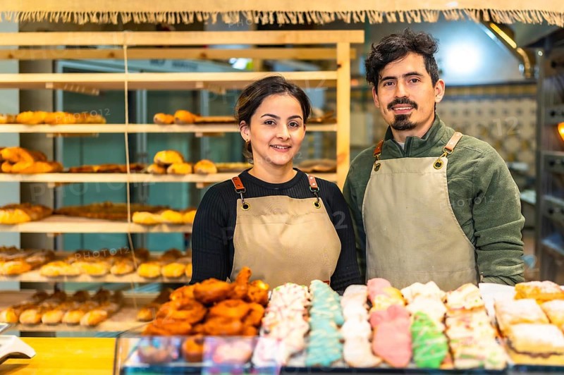 Portrait of male and female latin young coworkers in an artisan bakery shop