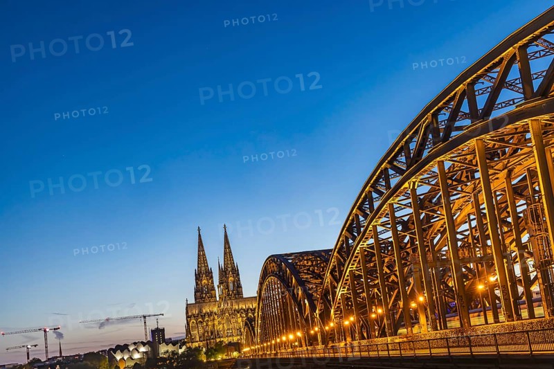 Cologne Cathedral, illuminated in the evening. Hohenzollern Bridge, railway bridge over the Rhine. City view of Cologne, North Rhine-Westphalia, Germany, Europe