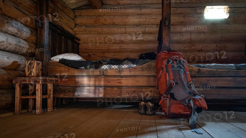 Rustic interior of a wooden hut with small beds and a rucksack and hiking boots, Olavsweg or Olavsleden, backdrop Kristin Lavranstochter film, Jørundgard Middelaldersenter, Olavsweg or Olavsleden, Sel municipality, Gudbrandsdalen, Norway, Europe