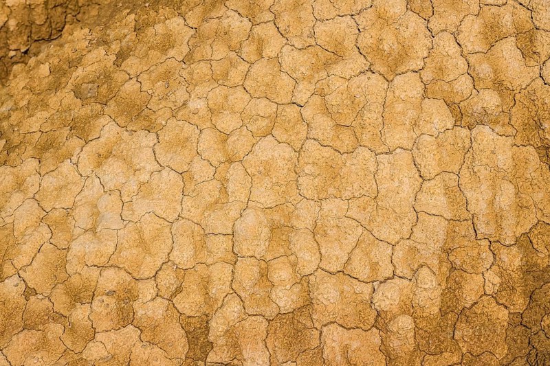 Cracked earth texture forming interesting patterns in bardenas reales desert, navarre, spain, highlighting the impact of drought and arid conditions