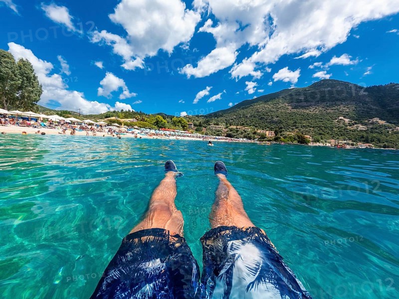 A man resting in the sea on the beach in summer of Paralia Mikros Gialos in the south of the island of Lefkada. Greece