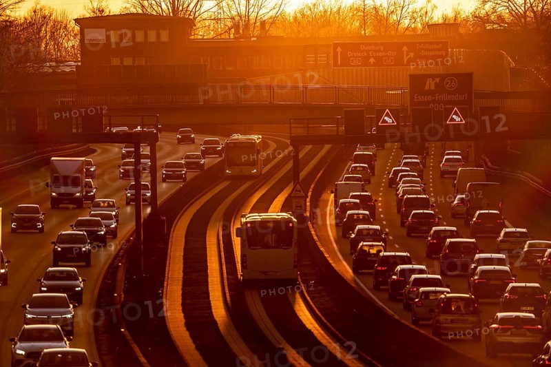 Motorway A40, dense, slow-moving traffic jam, evening traffic at the Essen-Kray junction, low sun, public transport bus lane in the middle of the motorway, North Rhine-Westphalia, Germany, Europe