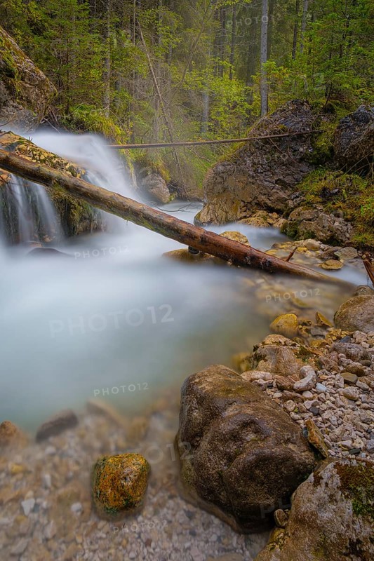 A tree trunk lies across a waterfall, long exposure, Dolomites, Puez-Geisler nature park Park, St. Magdalena, Villnöß, Funes, Villnößtal, South Tyrol, Italy, Europe