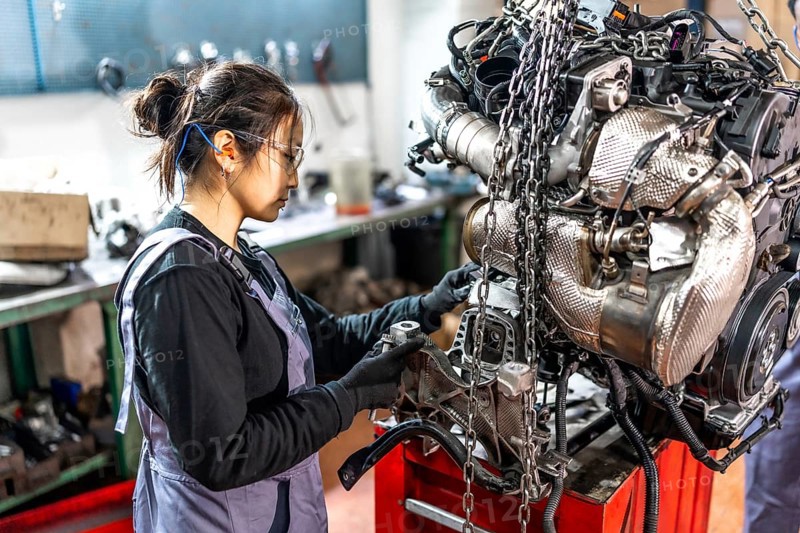 Skilled mechanic assembling engine parts in a professional workshop, showcasing expertise and precision in automotive repair