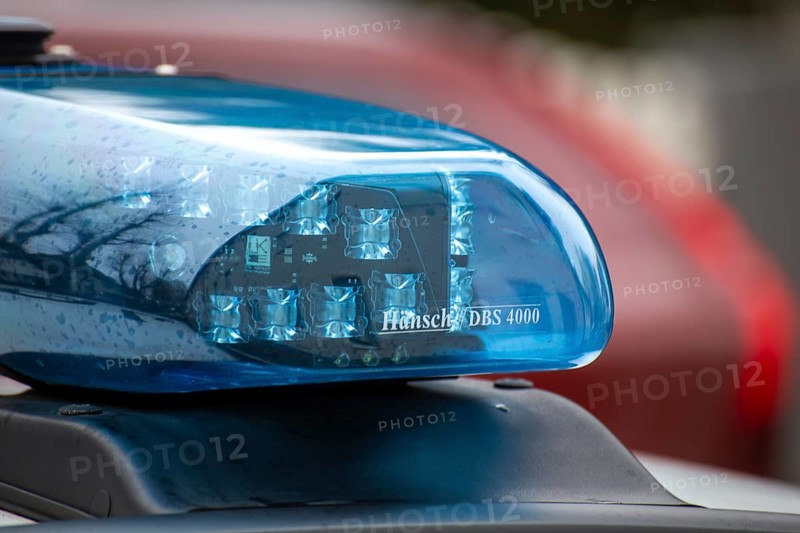 Symbolic image of a police operation: close-up of a flashing blue light on a police car