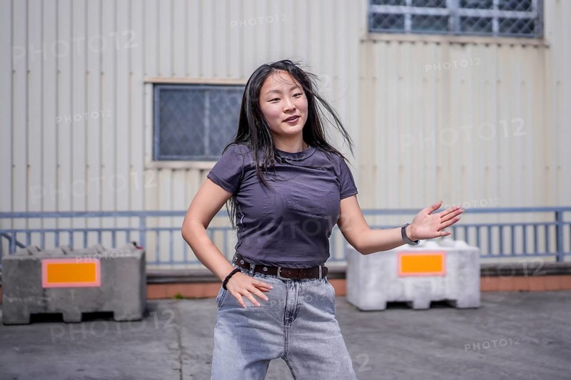Female asian young artist dancing K-pop korean dance alone in the city