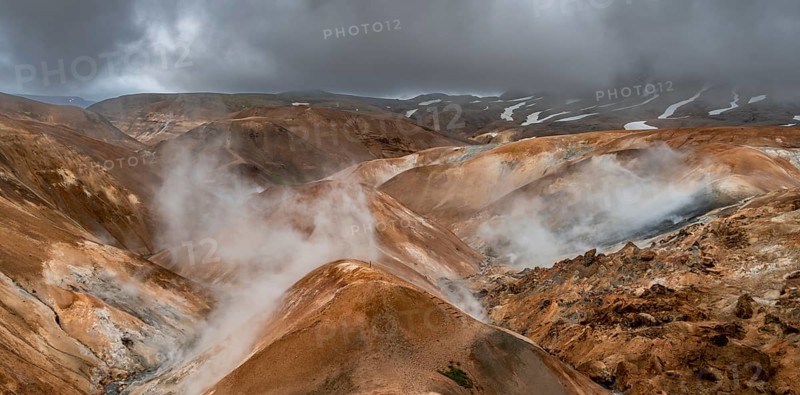 Steaming streams between colourful rhyolite mountains with snowfields, Hveradalir geothermal area, Kerlingarfjöll, Icelandic highlands, Iceland, Europe