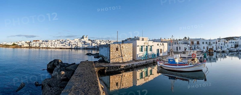 Panorama, view of the town of Naoussa and blue sea, harbour with fishing boats and reflection, white Cycladic houses and church of Agios Faneromeni, Paros, Cyclades, Greece, Europe
