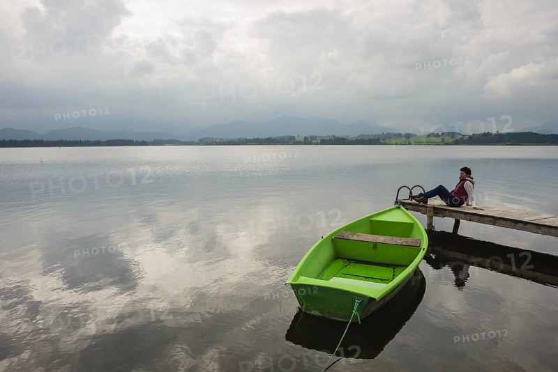 Woman 50-55, wooden jetty, green rowing boat, Hopfensee, Hopfen am See, near Füssen, Ostallgäu, Allgäu, Bavaria, Germany, Europe