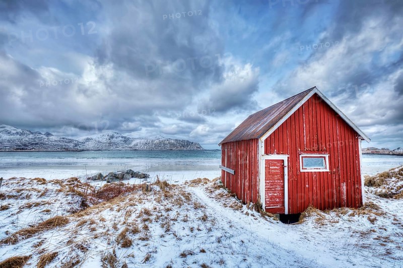 High Dynamic Range (HDR) image of red rorbu house shed on beach of fjord. Skagsanden beach, Lofoten islands, Norway, Europe
