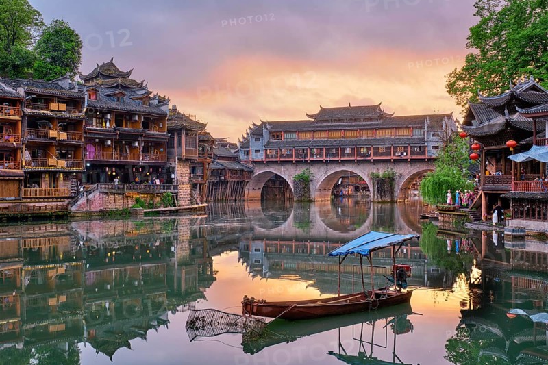 Chinese tourist attraction destination, Feng Huang Ancient Town (Phoenix Ancient Town) on Tuo Jiang River illuminated at night. Hunan Province, China, Asia