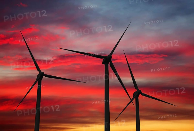 Green renewable energy concept, wind generator turbines in sky on sunset