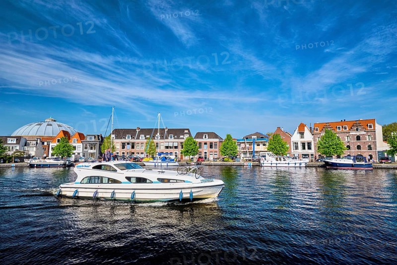 HAARLEM, NETHERLANDS, MAY 6, 2017: Boats and houses on Spaarne river with blue sky. Haarlem, Netherlands