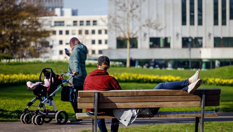 A couple relaxing on a park bench in the city garden in times of the corona crisis, Essen, Ruhr area, North Rhine-Westphalia, Germany, Europe