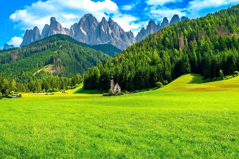 Green meadow with st. Magdalena church and stunning odle mountain range in dolomites, italy