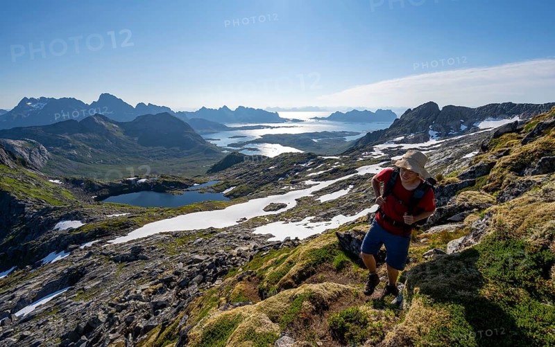 View of mountains and fjord landscape, mountaineers at the summit of Rundfjellet, Austenesfjord and Hellskarvatnet lake, Svolvaer, Nordland, Norway, Europe