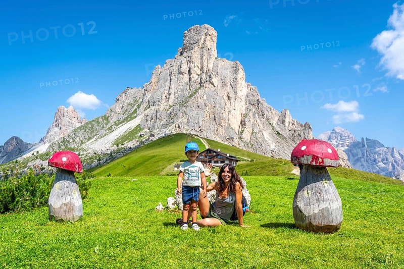Mother and son enjoying a summer vacation in the stunning italian dolomites, surrounded by the breathtaking scenery of giau pass