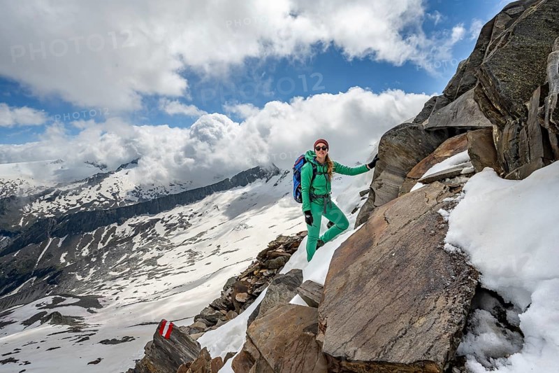 Mountaineer on a rocky hiking trail with snow, mountain panorama with snow-covered mountain peaks in the background, Berliner Höhenweg, Zillertal Alps, Tyrol, Austria, Europe