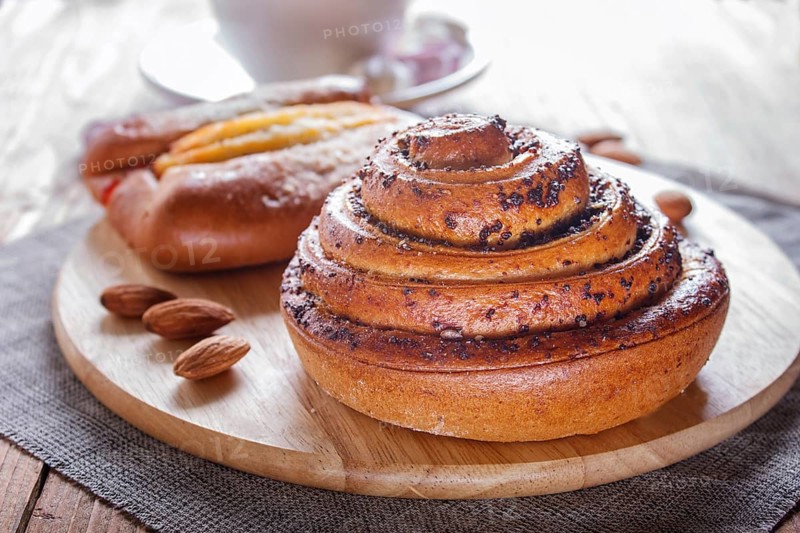 A cup of hot chocolate and buns on brown wooden background. close up