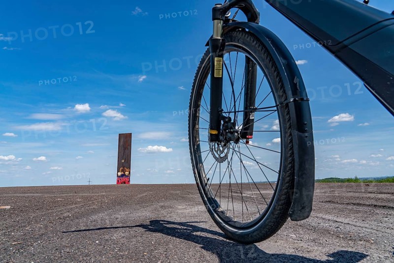 Cycling in the Ruhr area, on the Schurenbach slag heap, Bramme landmark for the Ruhr area by artist Richard Serra, Essen, North Rhine-Westphalia, Germany, Europe