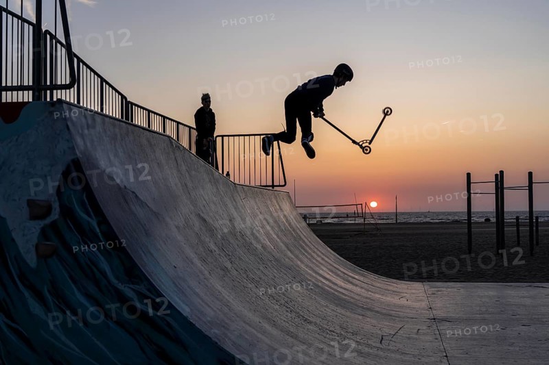 Skater, scooter in a halfpipe at the beach of Scheveningen, sunset, Netherlands