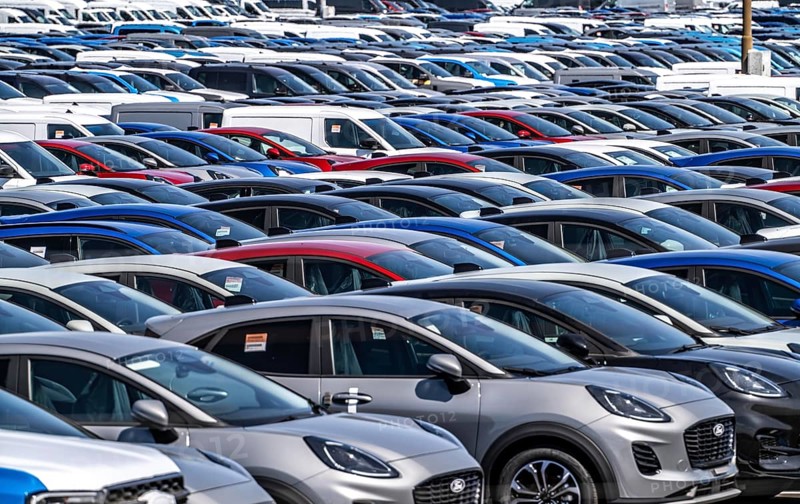 Storage area for new cars in the port of Vlissingen-Oost, vehicles are temporarily stored on over 100 hectares to ship them from Europe to the United Kingdom, Ford cars, others such as models from the Chinese car manufacturer BYD are delivered from here in Europe, wind farm, Netherlands