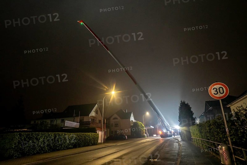 Transport of a 68 metre long, 22 tonne blade of a wind turbine, here in Breckerfeld, with a self-propelled Blade-Lifter vehicle, over a 40 km long route, over 2 nights, in the Bergisches Land, through towns, villages, over country roads, narrow through roads, to the construction site of the wind turbine near Hagen, North Rhine-Westphalia, Germany, Europe