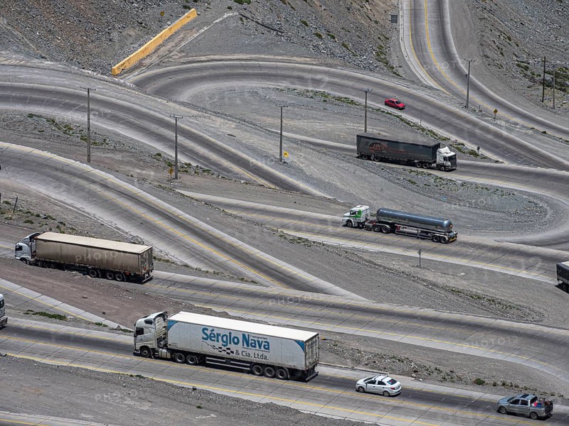 Heavy traffic of trucks on mountain pass Los Caracoles, The Snails, road connecting Chile and Argentina, aerial view, Chile, South America