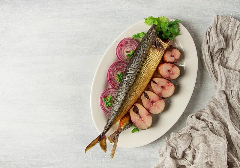 Smoked mackerel, top view, with spices, on a wooden table, no people, selective focus