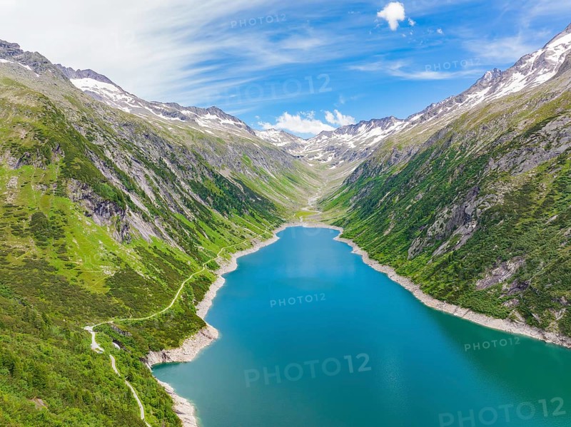 Blue lake, surrounded by high mountains and green, overgrown terrain under a bright blue sky, Klein Tibet, Zillertal, Austria, Europe